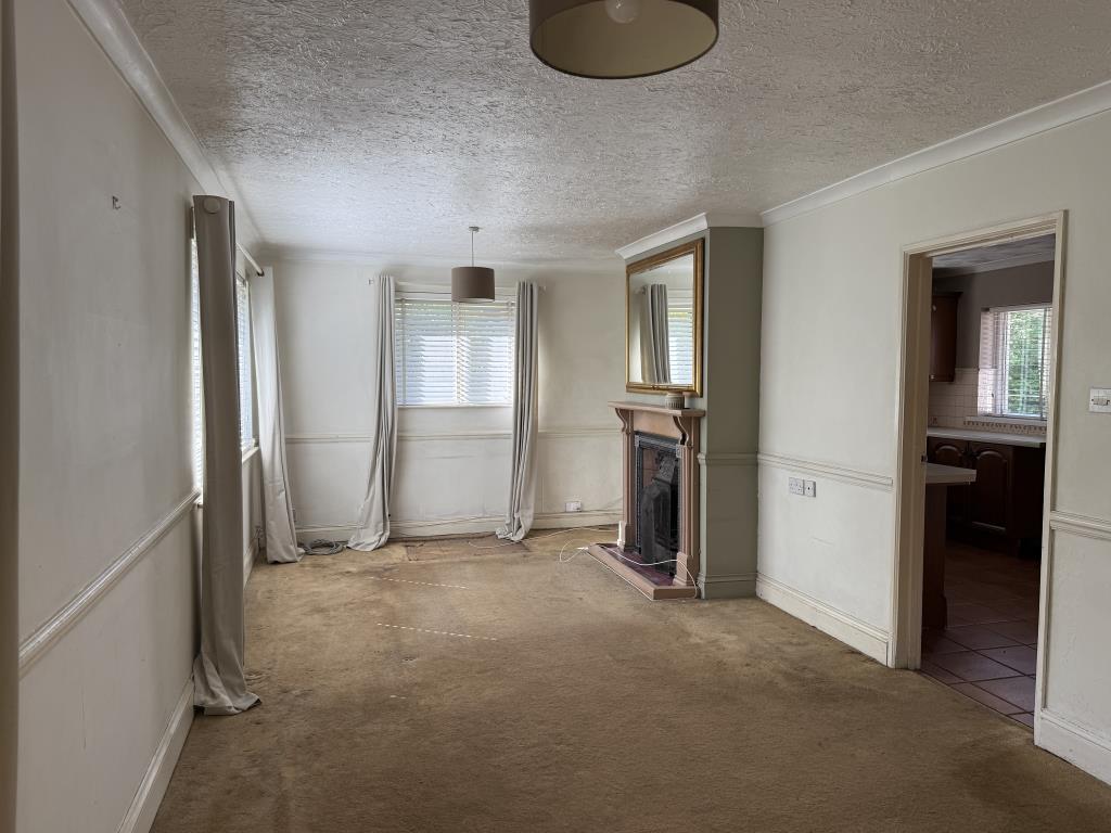 Lot: 112 - VACANT THREE-BEDROOM BUNGALOW ON PLOT OF 0.3 ACRES - Living room with feature fireplace